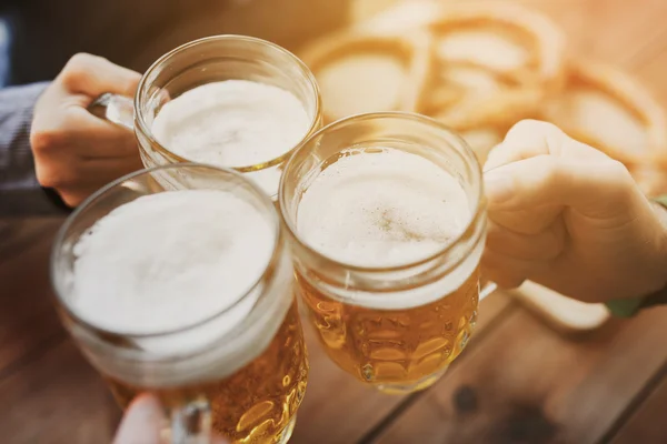 Close up of hands with beer mugs at bar or pub — Stock Photo, Image