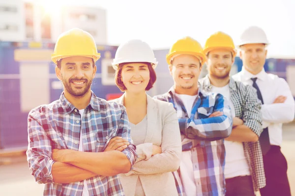 Gruppo di costruttori sorridenti in hardhats all'aperto — Foto Stock