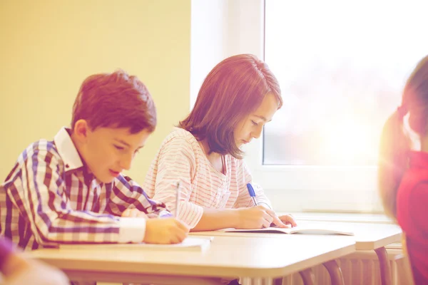 Groep van school-kids schrijven test in klas — Stockfoto