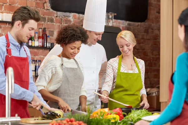 Amis heureux et chef cuisinier cuisine dans la cuisine — Photo