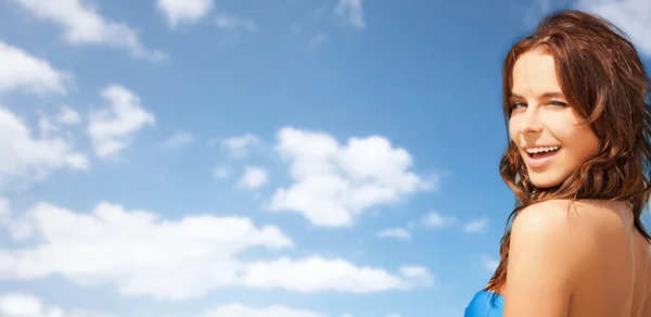Gelukkige mooie vrouw over blauwe hemel en wolken — Stockfoto