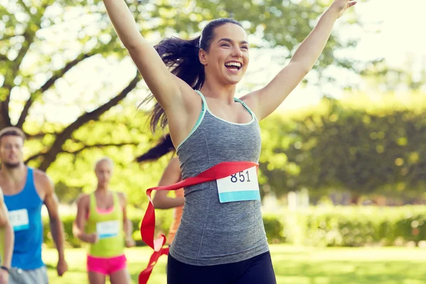 Feliz jovem corredor feminino ganhando no acabamento da corrida — Fotografia de Stock