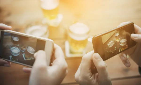 Close-up de mãos com smartphone imagem de cerveja — Fotografia de Stock