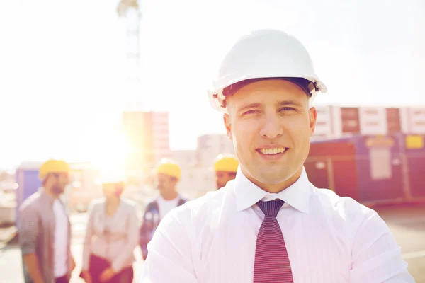 Groep van lachende bouwers in hardhats in openlucht — Stockfoto