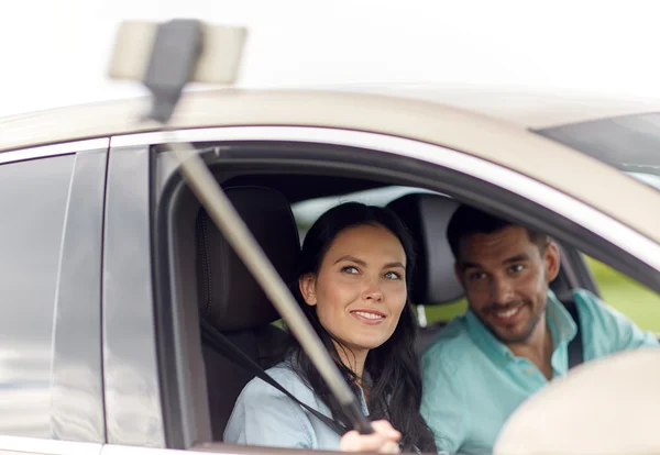 Счастливая пара в машине делает селфи со смартфоном — стоковое фото