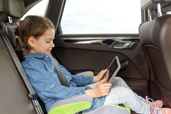 Щаслива маленька дівчинка з планшетним ПК за кермом в машині — стокове фото