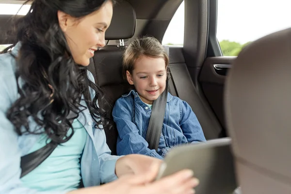 Gelukkige familie met tablet pc rijden in auto — Stockfoto