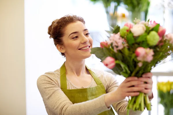 Улыбающаяся цветочница делает букет в цветочном магазине — стоковое фото