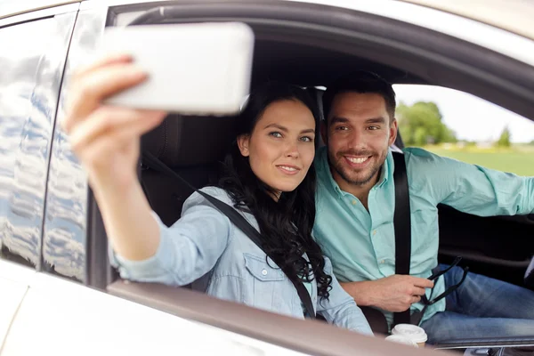 Casal feliz no carro tomando selfie com smartphone — Fotografia de Stock