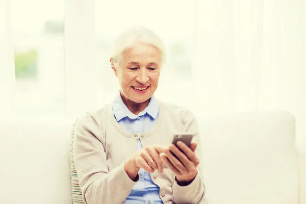 Ηλικιωμένη γυναίκα με μηνύματα smartphone στο σπίτι — Φωτογραφία Αρχείου