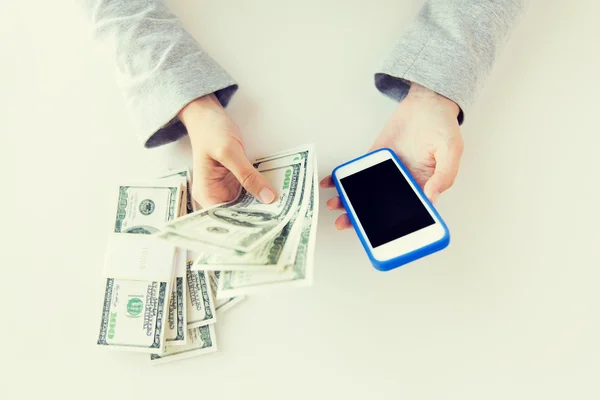 Primo piano delle mani della donna con smartphone e denaro — Foto Stock