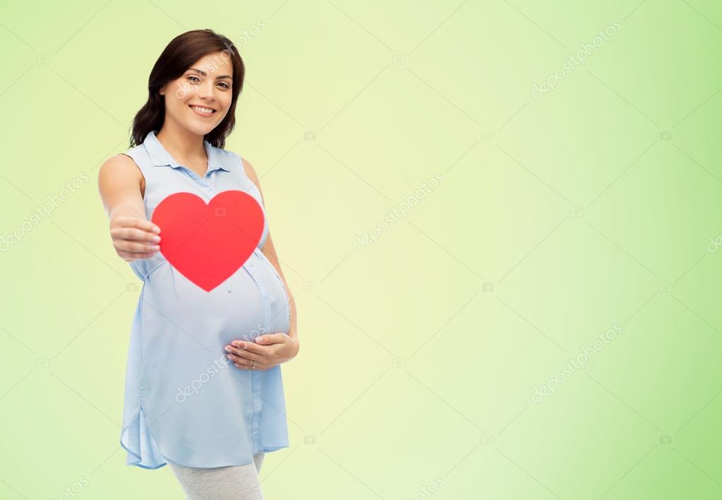 Happy pregnant woman with red heart touching belly Stock Photo by  ©Syda_Productions 120840700
