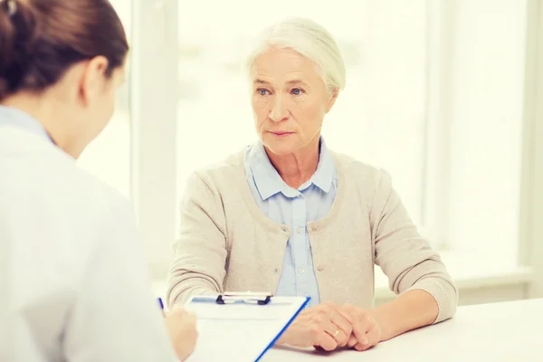 Médecin avec presse-papiers et femme âgée à l'hôpital — Photo