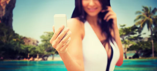 해변에서 스마트폰으로 셀카를 찍고 있는 젊은 여자 — 스톡 사진