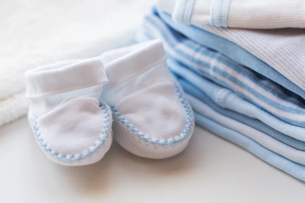 Закрыть бэби-буты и одежду для новорожденных — стоковое фото