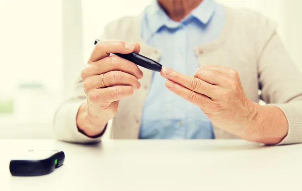 血糖チェック glucometer と年配の女性 — ストック写真