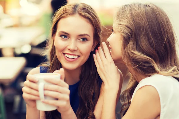 Young women drinking coffee and talking at cafe — Stock Photo, Image