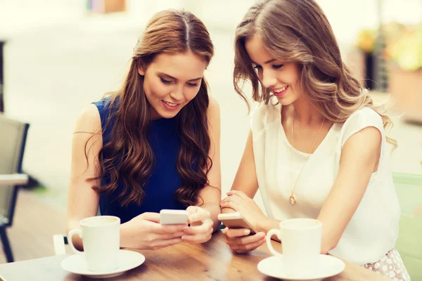 Mujeres con teléfonos inteligentes y café en la cafetería al aire libre — Foto de Stock