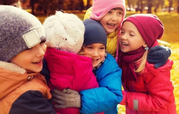 Группа счастливых детей, обнимающихся в осеннем парке — стоковое фото