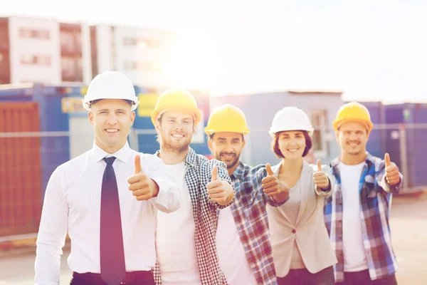 Grupo de constructores sonrientes en hardhats al aire libre — Foto de Stock