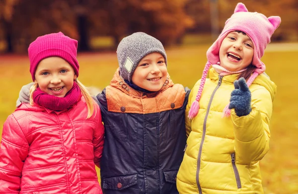 Grupo de niños felices abrazándose en el parque de otoño —  Fotos de Stock