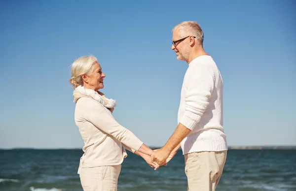 Felice coppia anziana che si tiene per mano spiaggia estiva — Foto Stock