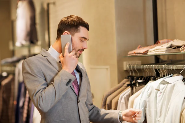 Homem feliz chamando no smartphone na loja de roupas — Fotografia de Stock