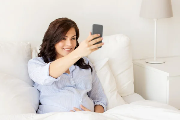 Mulher grávida tomando selfie smartphone em casa — Fotografia de Stock