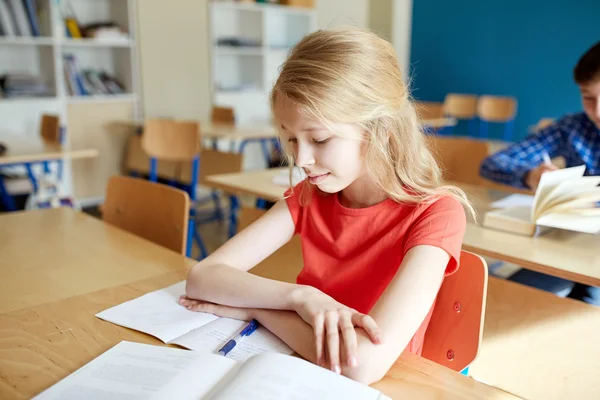 Estudante menina com livro na escola lição — Fotografia de Stock