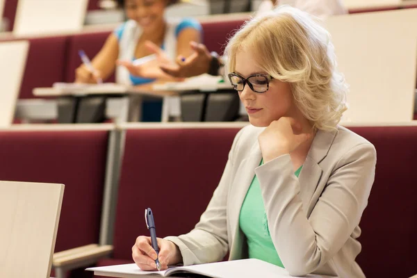 Étudiant fille écriture à notebook dans salle de conférence — Photo