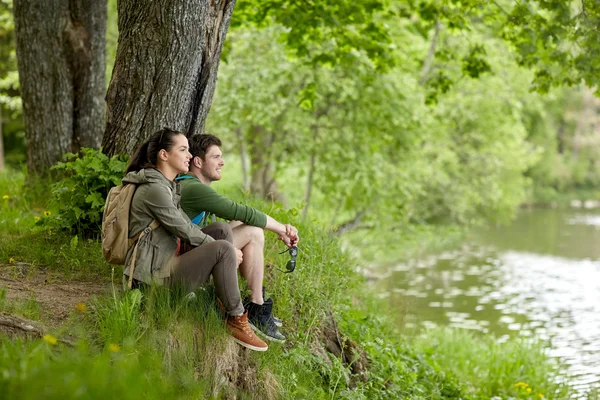 Smilende par med rygsække i naturen - Stock-foto