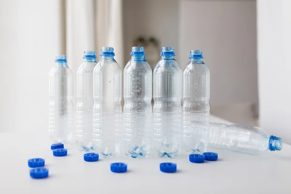 Primo piano di bottiglie d'acqua vuote e tappi sul tavolo — Foto Stock