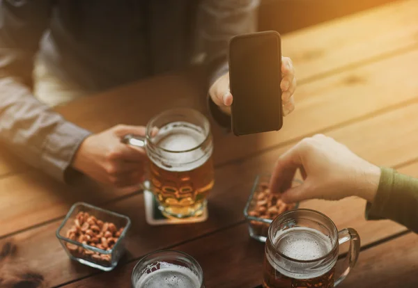 Close up of friends with smartphone and beer — Stock Photo, Image