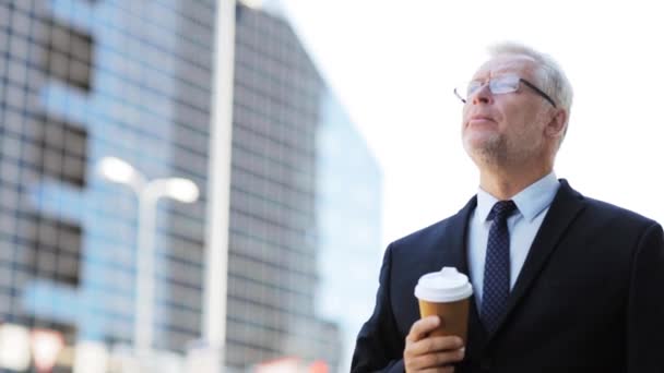 Старший бизнесмен пьет кофе на городской улице — стоковое видео