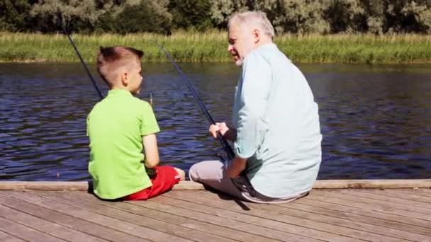 Grandfather and grandson fishing on river berth 21 — Stock Video