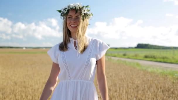 Glad ung kvinna i blomma krans på spannmål fält — Stockvideo