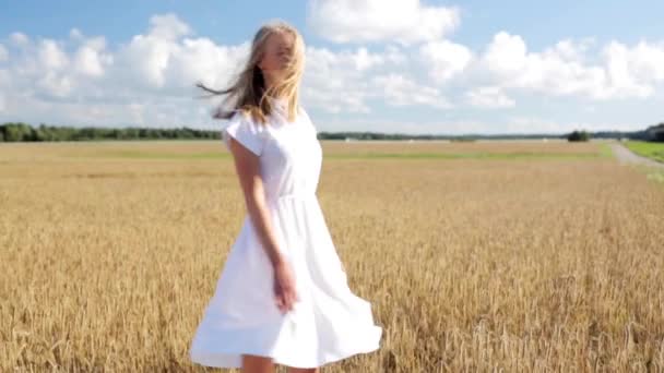Leende ung kvinna i vit klänning på spannmål fält — Stockvideo