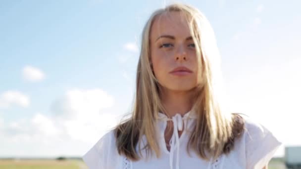 Jeune femme souriante en robe blanche à l'extérieur — Video