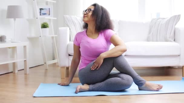 Femme africaine heureuse exerçant sur tapis à la maison — Video