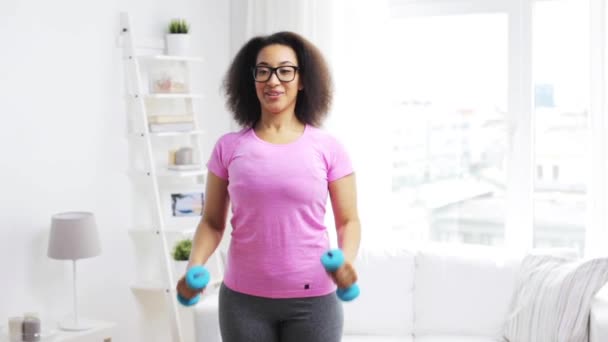 Mujer africana haciendo ejercicio con pesas en casa — Vídeo de stock