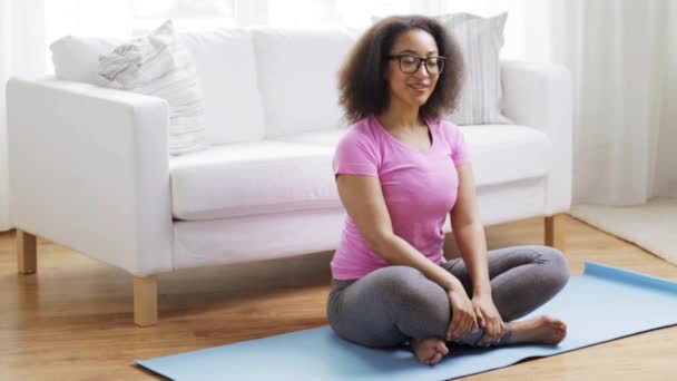 Femme africaine heureuse exerçant sur tapis à la maison — Video