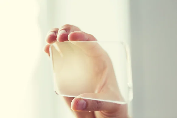 Fechar a mão masculina com smartphone transparente — Fotografia de Stock