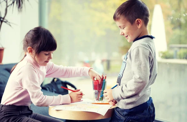 Счастливые девочка и мальчик рисуют дома — стоковое фото