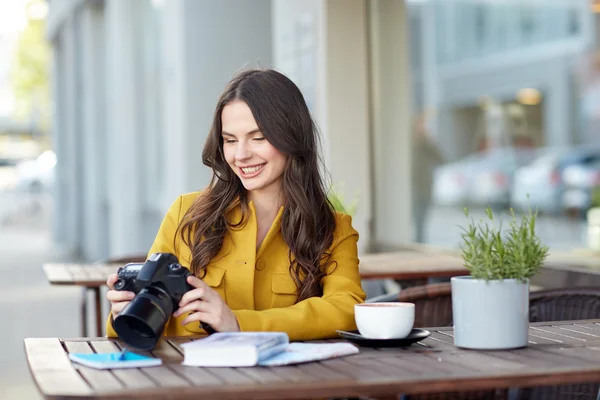 Femme touristique heureuse avec caméra au café de la ville — Photo