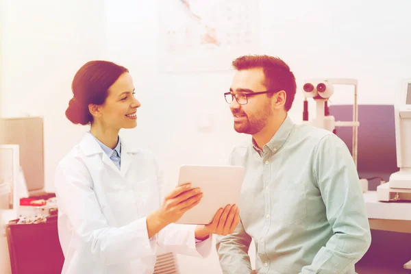 Optician with tablet pc and patient at eye clinic — Stock Photo, Image