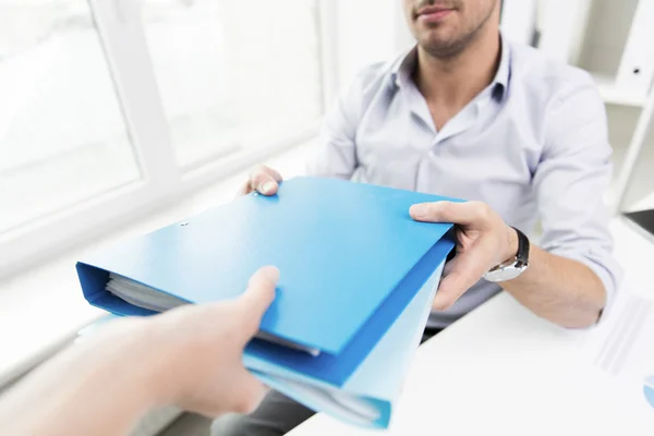 Close up of businessman taking folders from hand — Stock Photo, Image
