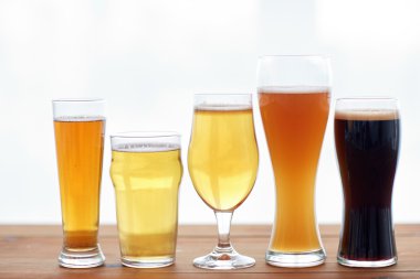 close up of different beers in glasses on table clipart