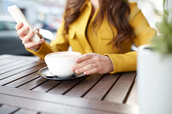 Закрытие женщины на смартфон в кафе — стоковое фото