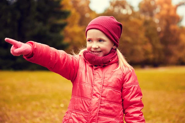 Happy little girl pointing finger in autumn park — 图库照片