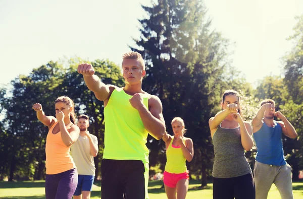 Grupo de amigos o deportistas que hacen ejercicio al aire libre — Foto de Stock